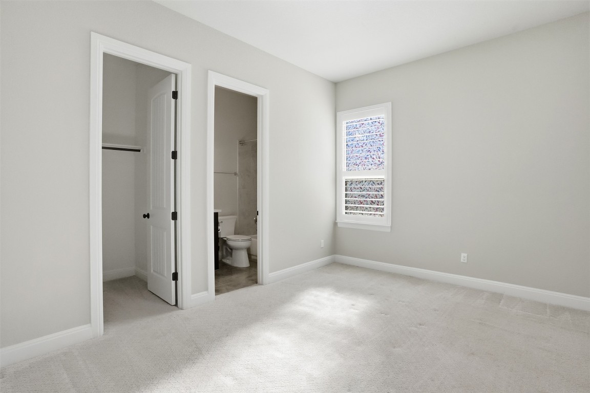 1441 River Vista Road Georgetown, TX 78628 - Photo 21 of 37 Unfurnished bedroom with a walk in closet, light colored carpet, and ensuite bathroom