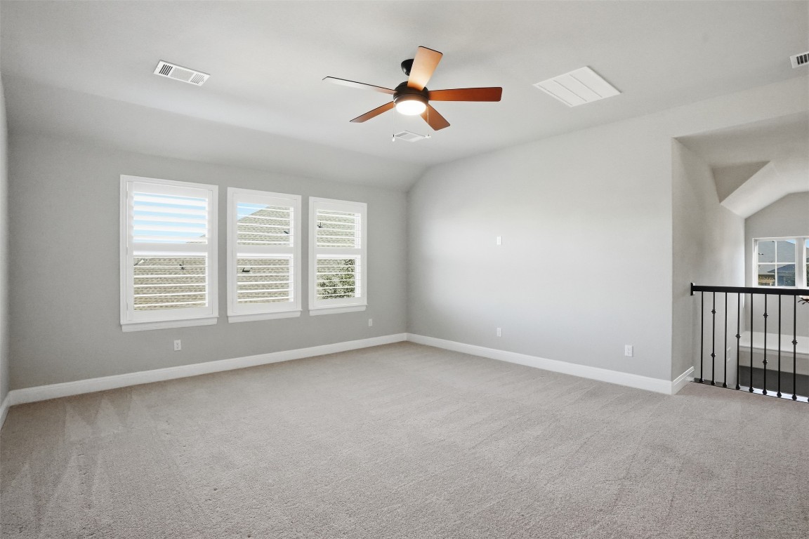 1441 River Vista Road Georgetown, TX 78628 - Photo 26 of 37 Spare room featuring lofted ceiling, plenty of natural light, light colored carpet, and ceiling fan