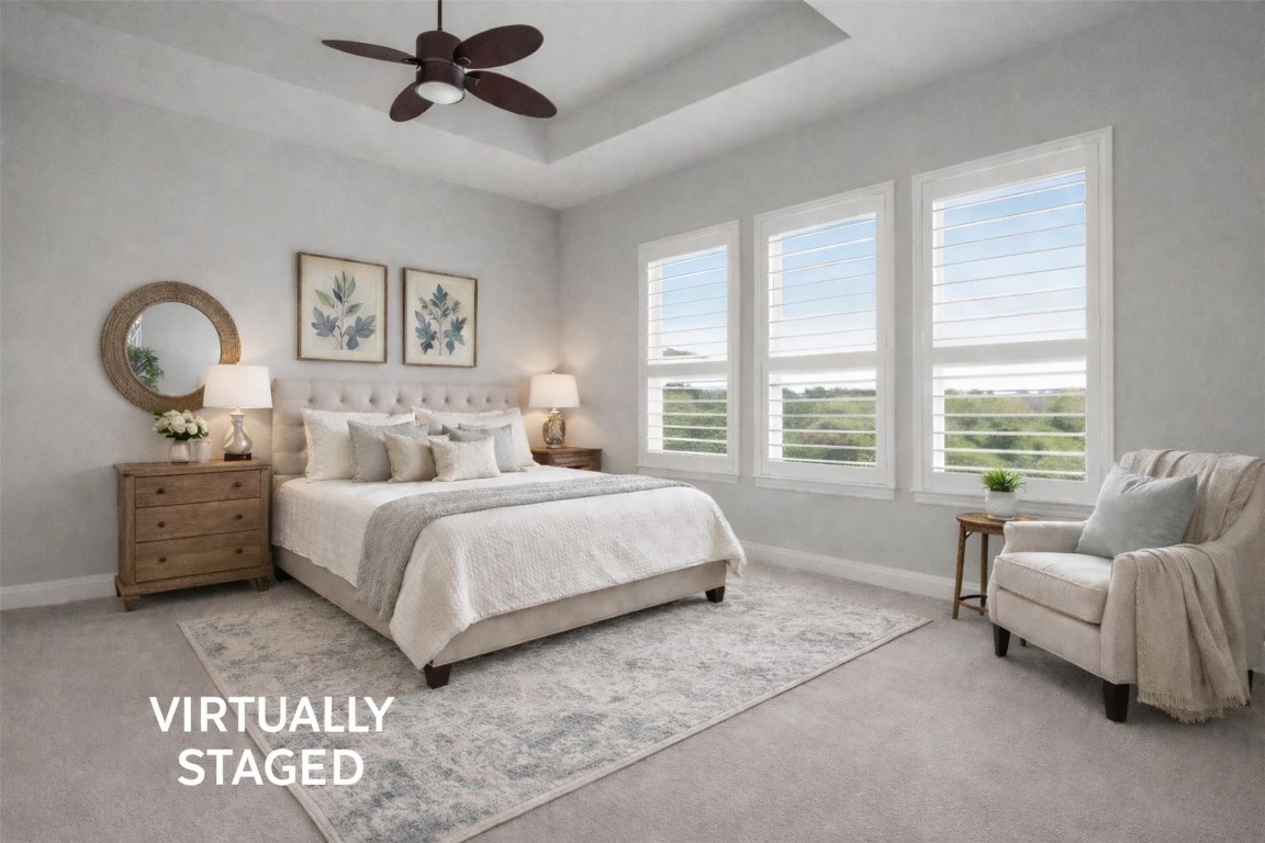 1441 River Vista Road Georgetown, TX 78628 - Photo 27 of 37 Bedroom with carpet flooring, a raised ceiling, and a ceiling fan overlooking an amazing view!