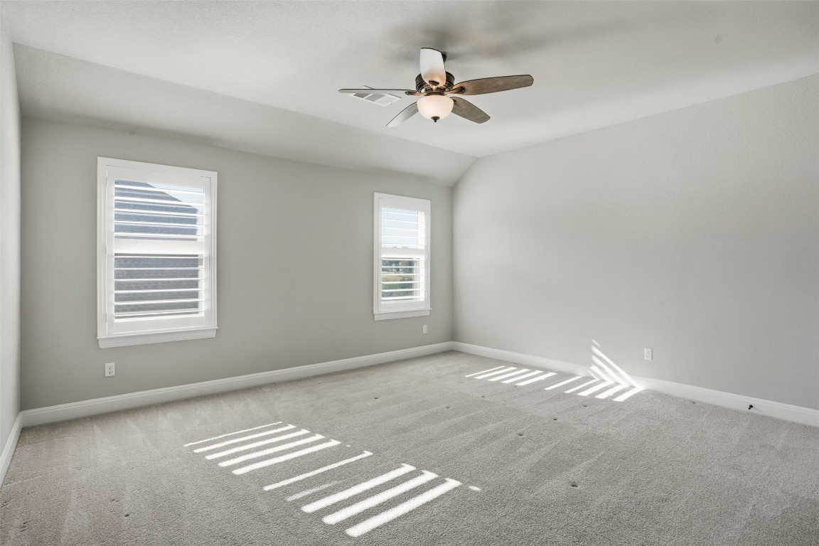 1441 River Vista Road Georgetown, TX 78628 - Photo 30 of 37 Empty room featuring carpet floors, vaulted ceiling, and ceiling fan