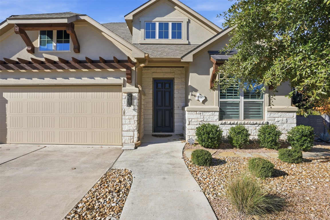 1441 River Vista Road Georgetown, TX 78628 - Photo 5 of 37 Craftsman inspired home with stone siding, a garage, concrete driveway, stucco siding, and a shingled roof