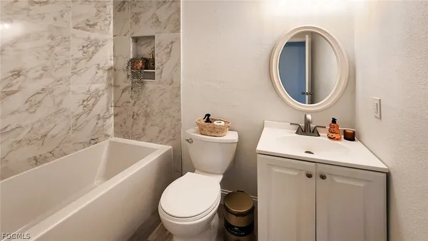a bathroom with a sink mirror bathtub and toilet