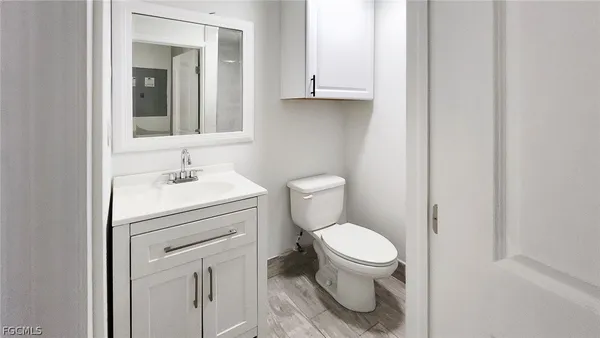 a bathroom with a toilet sink and mirror