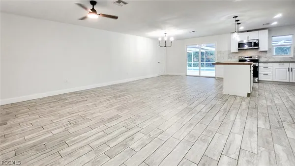 a view of empty room with wooden floor and window