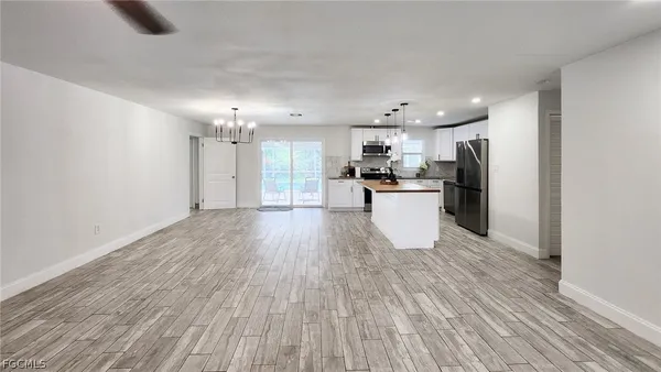 a large kitchen with a wooden floor and stainless steel appliances