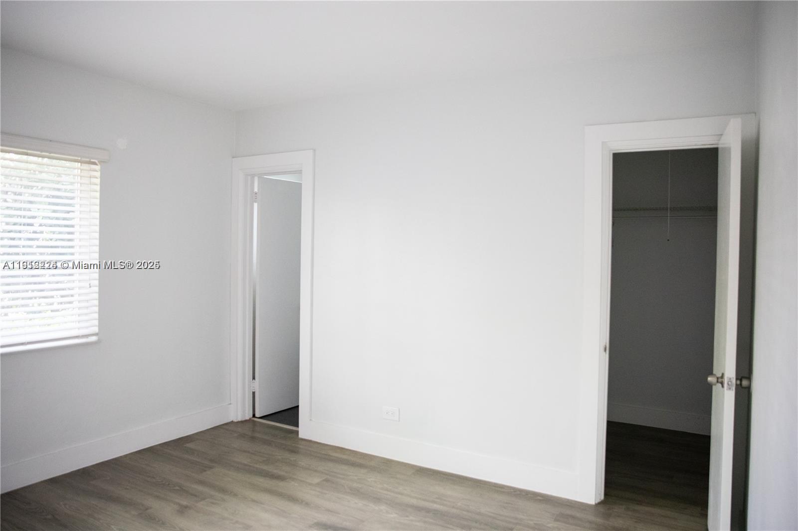 345 85th Street, Unit 7 Miami Beach, FL 33141 - Photo 11 of 13 an empty room with wooden floor closet and windows