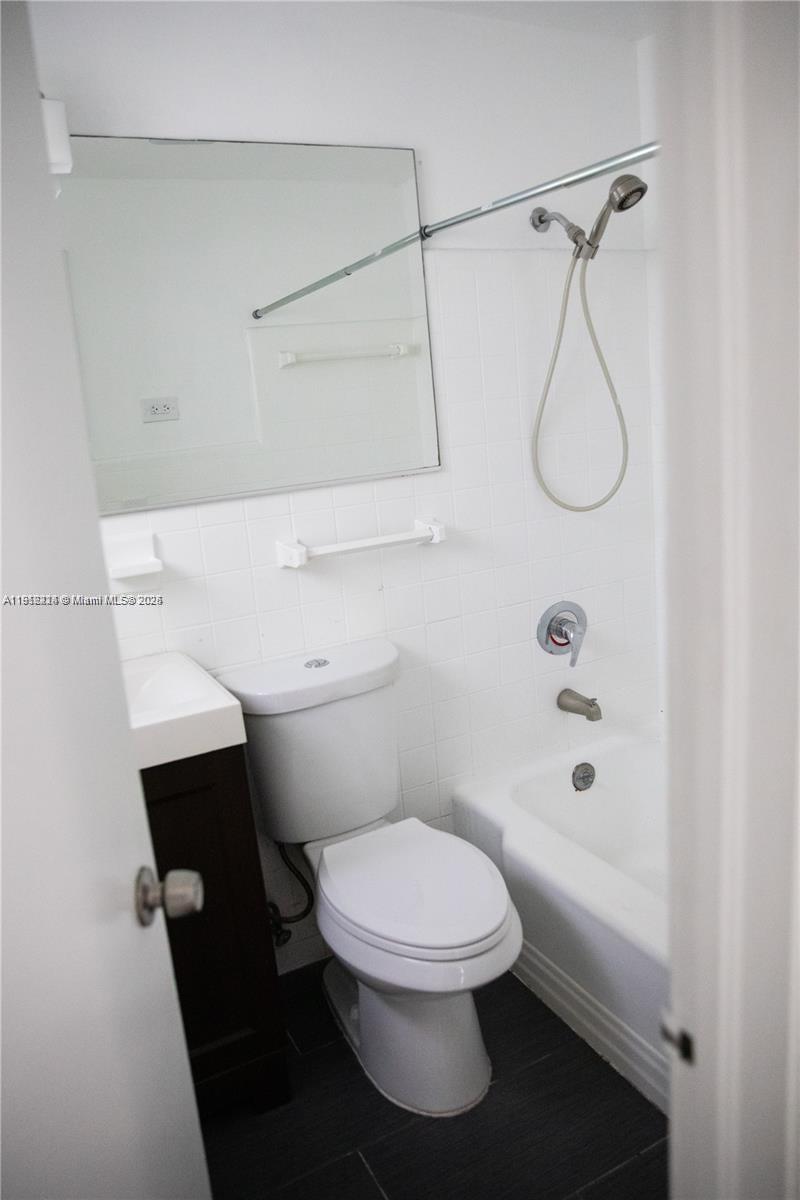 345 85th Street, Unit 7 Miami Beach, FL 33141 - Photo 8 of 13 a white toilet sitting next to a bathroom sink