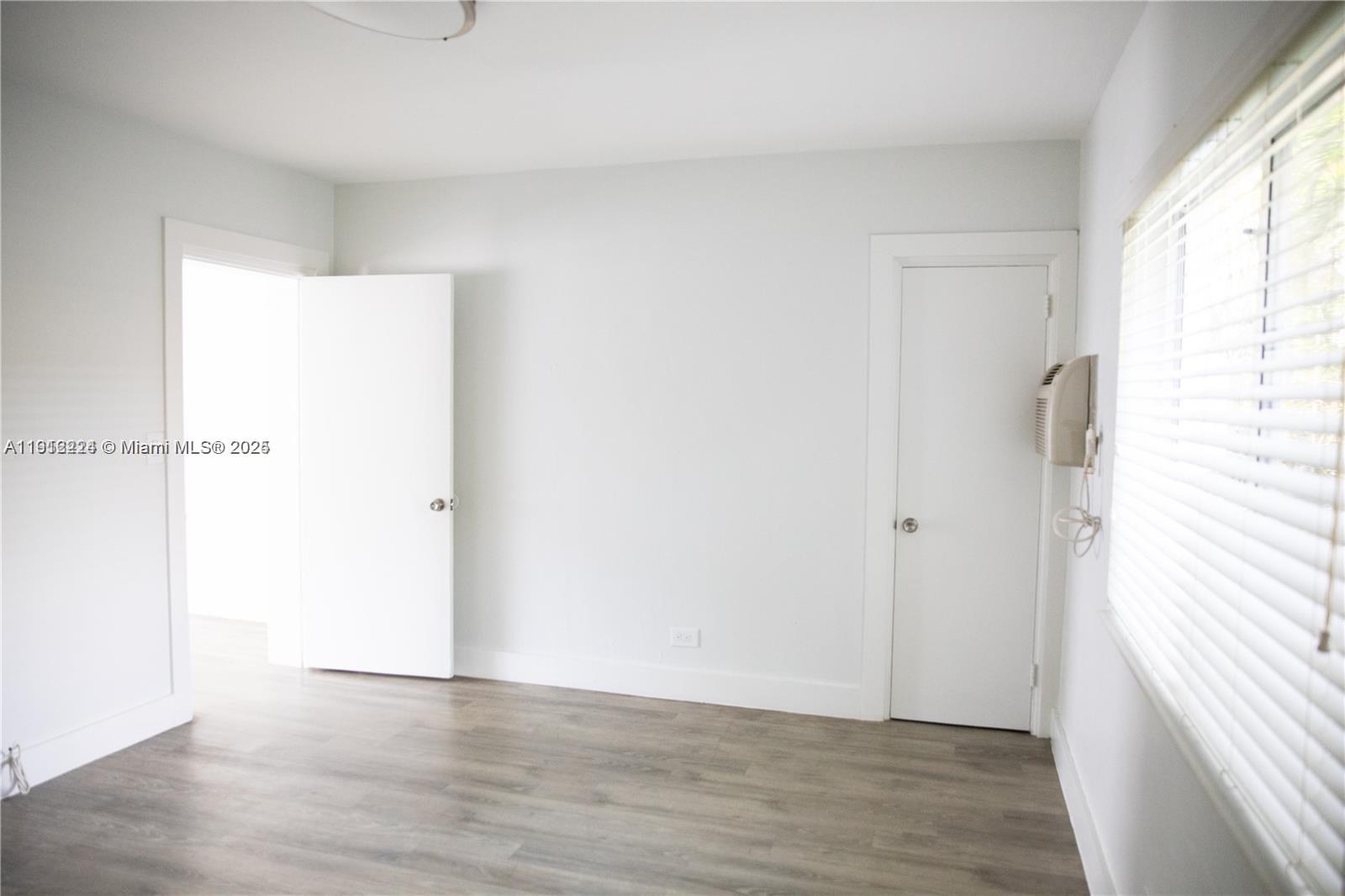 345 85th Street, Unit 7 Miami Beach, FL 33141 - Photo 9 of 13 a view of an empty room with wooden floor and a window