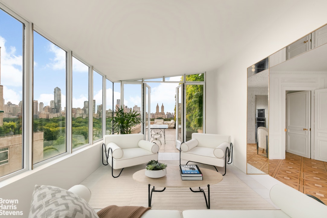 936 5th Avenue, Unit PH Manhattan, NY 10021 - Photo 10 of 21 a living room with furniture and a large window