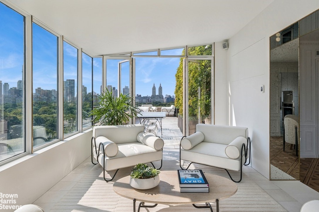 936 5th Avenue, Unit PH Manhattan, NY 10021 - Photo 9 of 21 a living room with furniture and a large window