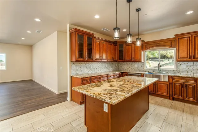 a kitchen that has a sink a microwave oven a stove and white cabinets