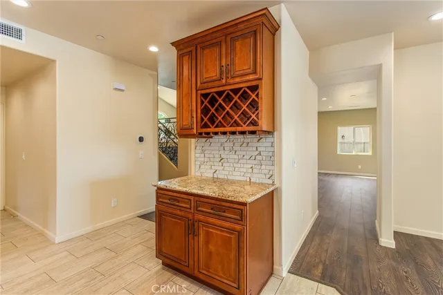 a view of an empty room with wooden floor and stairs