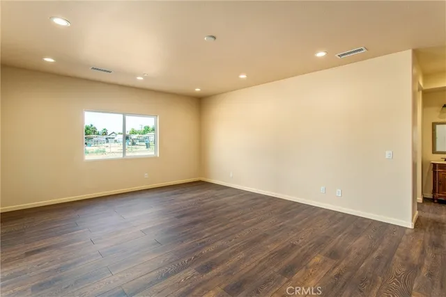 an empty room with wooden floor and window