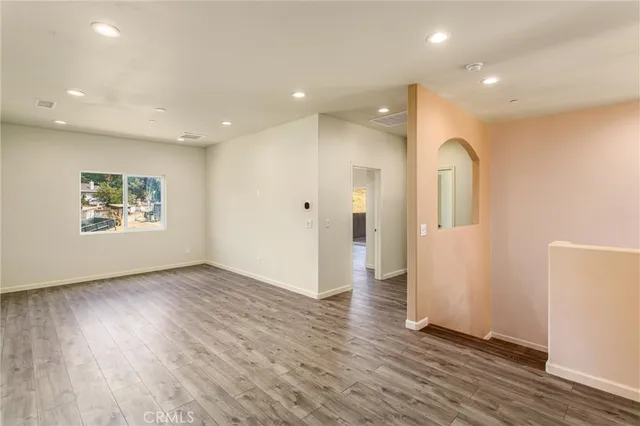 an empty room with wooden floor and a window