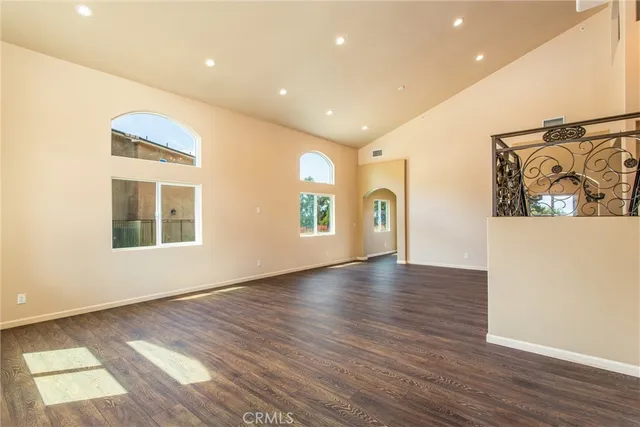 a view of a hallway with wooden floor and a bathroom