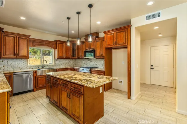 a kitchen with stainless steel appliances granite countertop a stove top oven microwave and refrigerator
