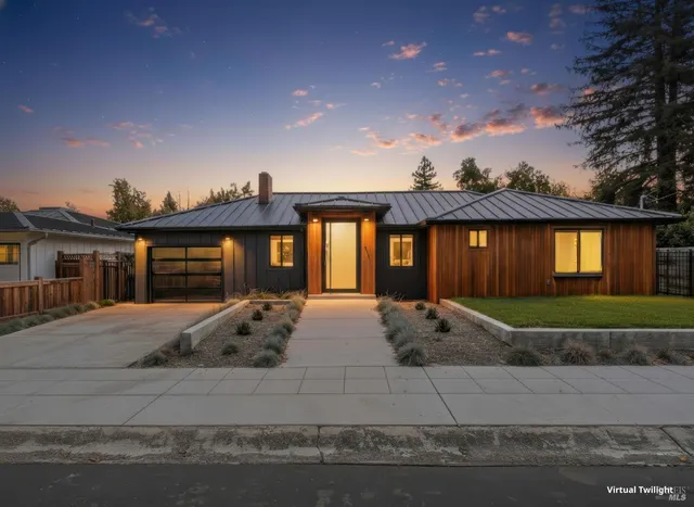 a front view of house with yard and trees in the background