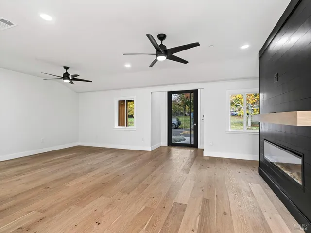 a living room with furniture a ceiling fan and a flat screen tv