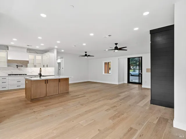 a large kitchen with stainless steel appliances kitchen island granite countertop a refrigerator and a sink