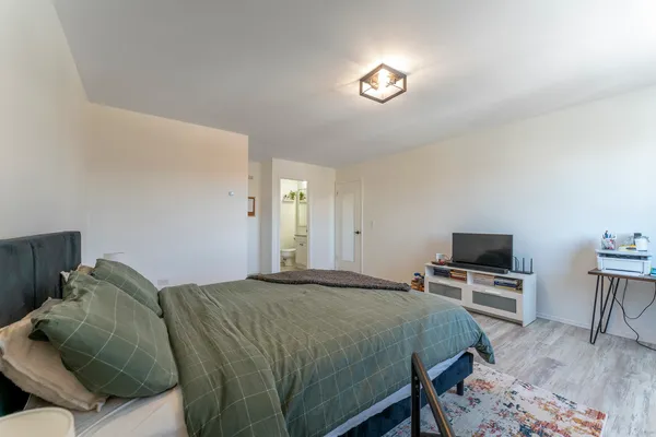a bed sitting in a bedroom and a tv