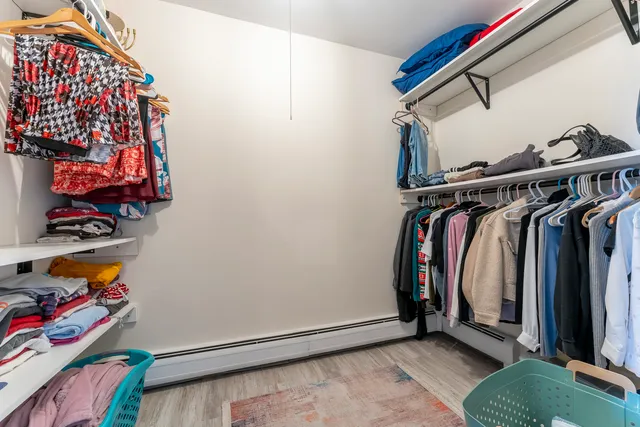 a view of walk in closet with clothes and shoes