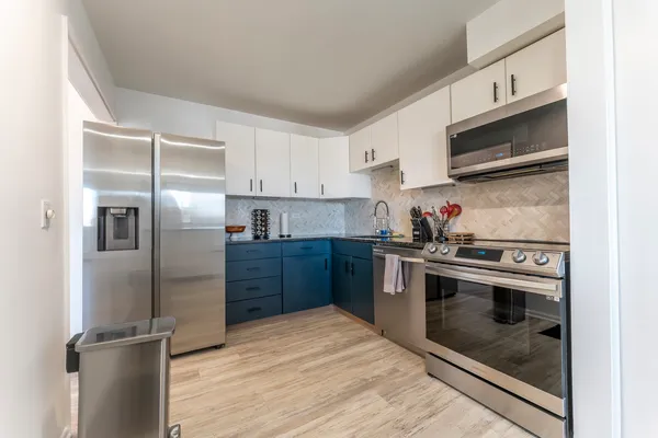 a kitchen with stainless steel appliances granite countertop a stove a refrigerator and a microwave