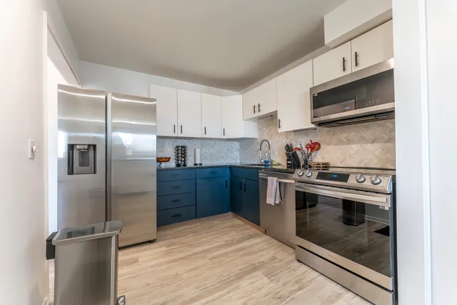 a kitchen with stainless steel appliances granite countertop a stove a refrigerator and a microwave