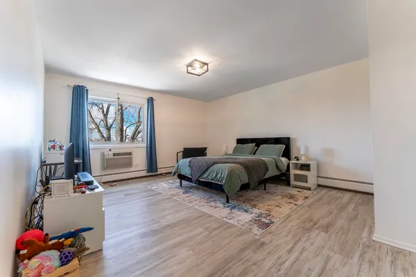 a bedroom with a bed and wooden floor