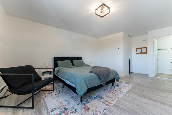 a bedroom with a bed and a chair