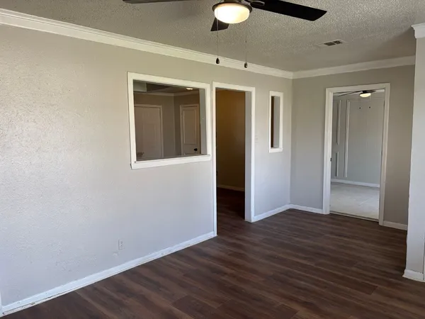 a view of an empty room with wooden floor