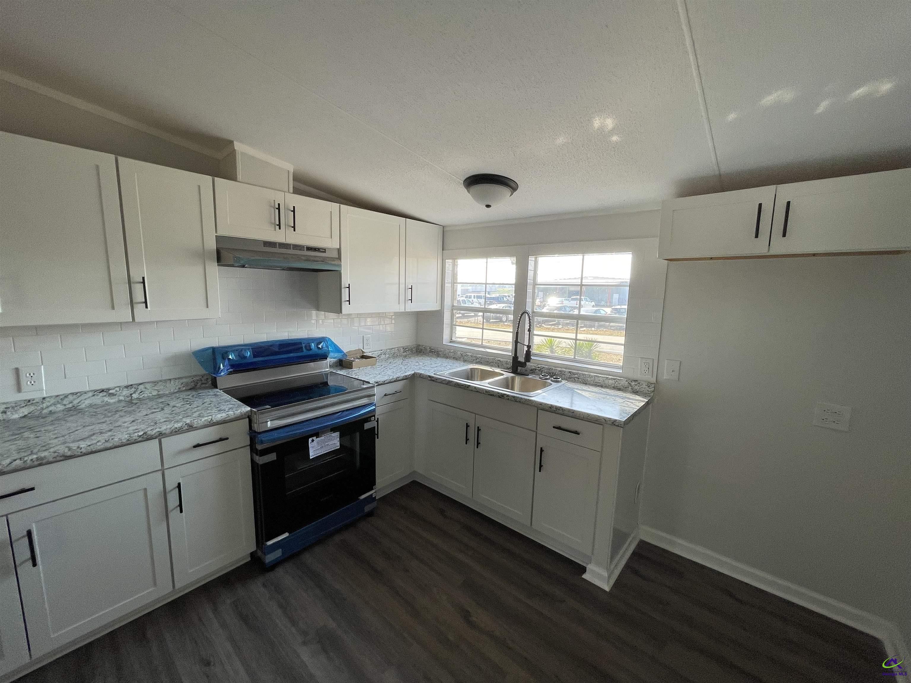 306 Dennard Road Unadilla, GA 31091 - Photo 6 of 14 a kitchen with sink cabinets and wooden floor