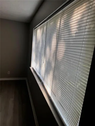 a view of an empty room with wooden floor and closet