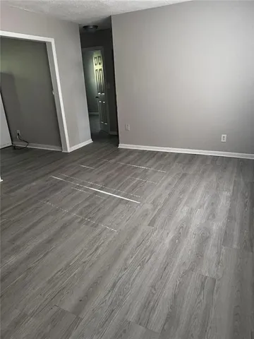 a view of a room that has wooden floor and windows in it
