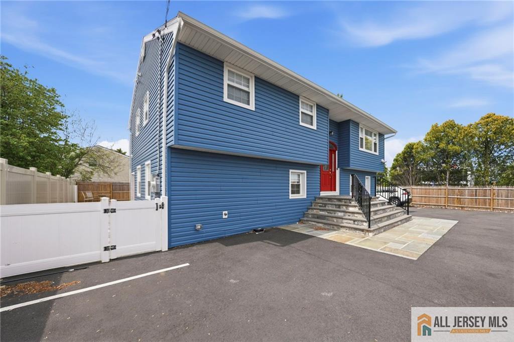 1084 Stelton Road Piscataway, NJ 08854 - Photo 3 of 20 a view of a house with a small yard and wooden fence