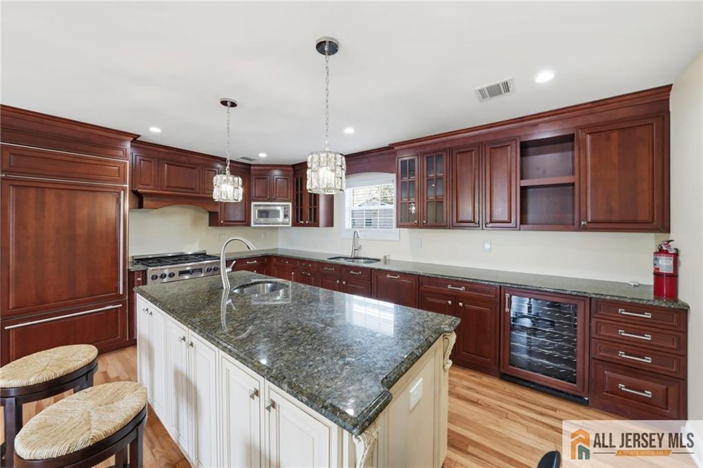 1084 Stelton Road Piscataway, NJ 08854 - Photo 5 of 20 a kitchen with stainless steel appliances granite countertop a sink a microwave and wooden cabinets
