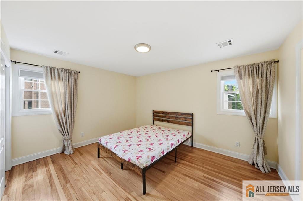 1084 Stelton Road Piscataway, NJ 08854 - Photo 7 of 20 a bedroom with a bed and wooden floor