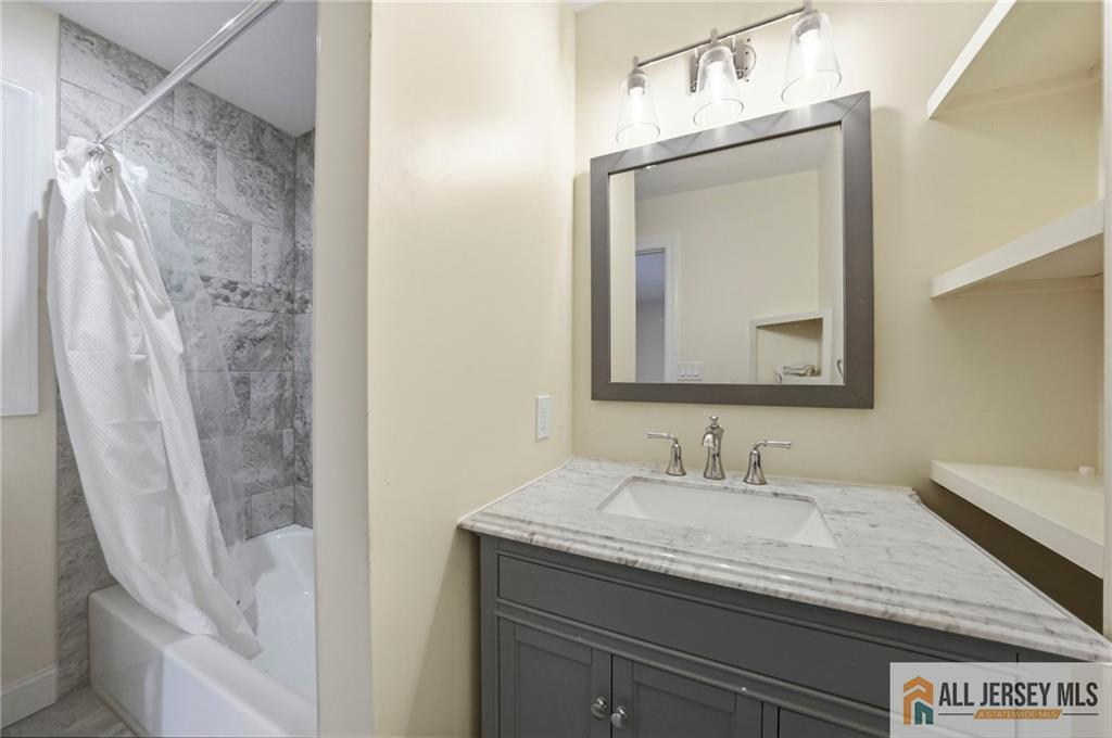 1084 Stelton Road Piscataway, NJ 08854 - Photo 8 of 20 a bathroom with a granite countertop sink a mirror and shower