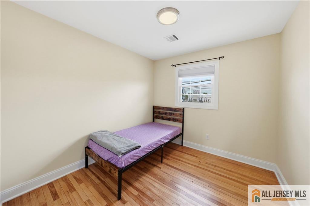 1084 Stelton Road Piscataway, NJ 08854 - Photo 10 of 20 a hallway with a bench and wooden floor