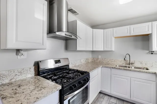 a kitchen with stainless steel appliances granite countertop a sink stove and cabinets