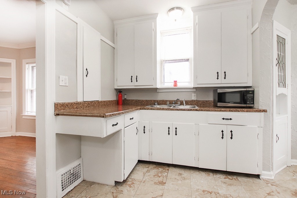 3973 Navahoe Road Cleveland, OH 44121 - Photo 7 of 14 Kitchen featuring stainless steel microwave, dark countertops, visible vents, and a sink