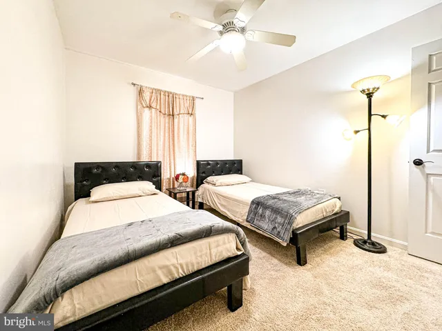 a bedroom with two beds and ceiling fan