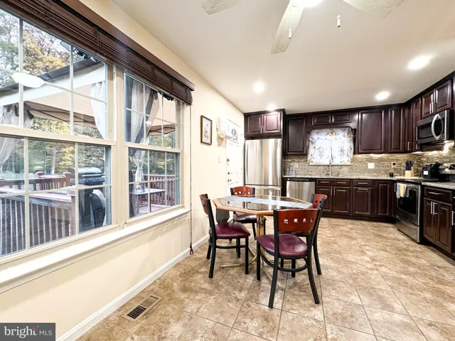 a view of a dining room with furniture a kitchen and chandelier