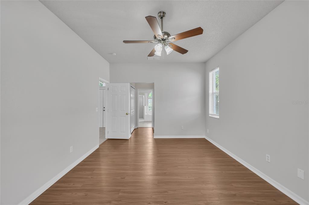 1047 Durango Loop Street Davenport, FL 33897 - Photo 11 of 35 a view of an empty room with wooden floor and a window