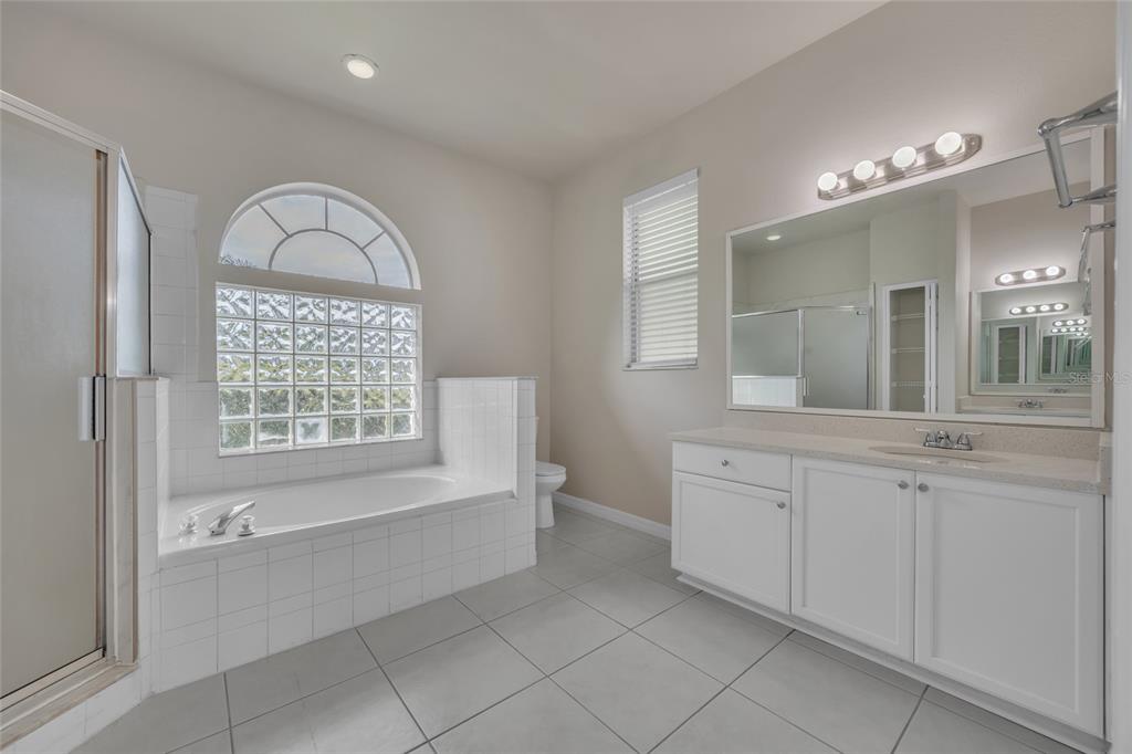 1047 Durango Loop Street Davenport, FL 33897 - Photo 12 of 35 a spacious bathroom with a mirror a bathtub and next to a window