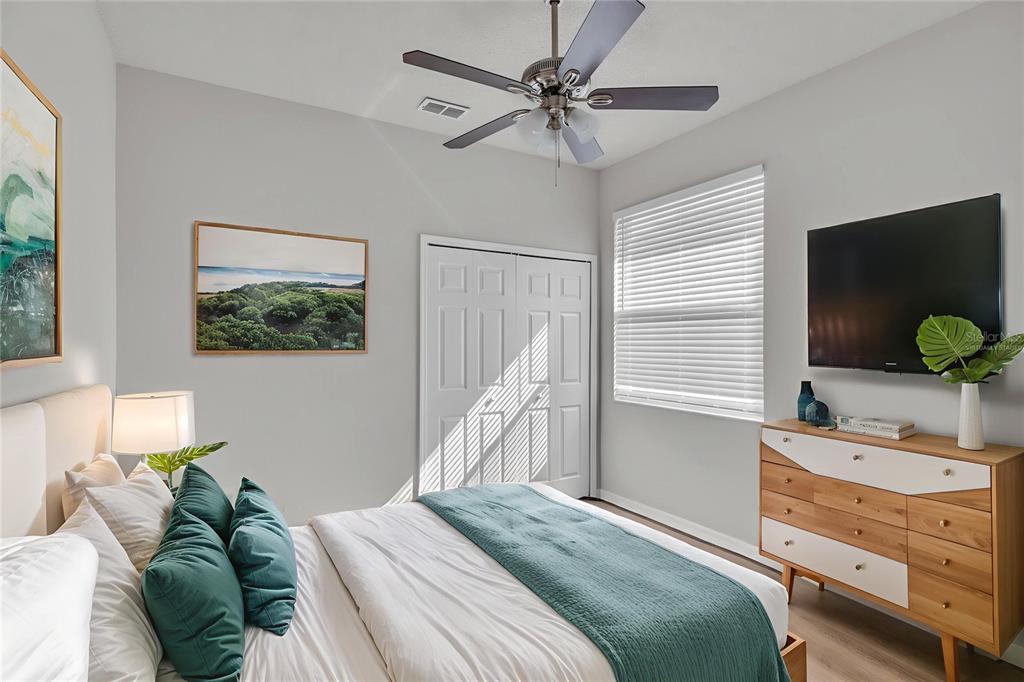 1047 Durango Loop Street Davenport, FL 33897 - Photo 22 of 35 a bedroom with a bed and a flat tv screen on dresser