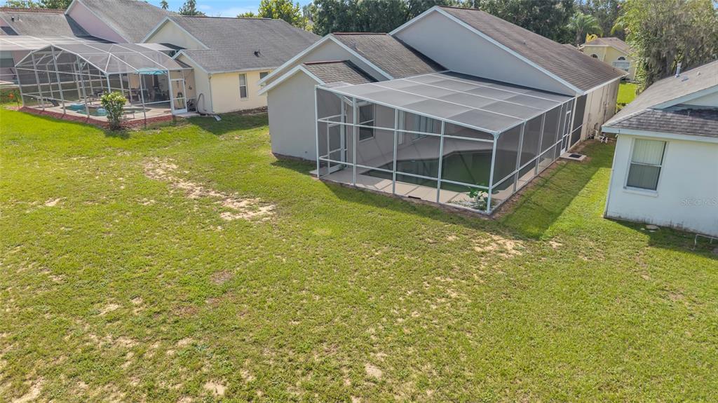 1047 Durango Loop Street Davenport, FL 33897 - Photo 28 of 35 a view of a house with a big yard and large trees