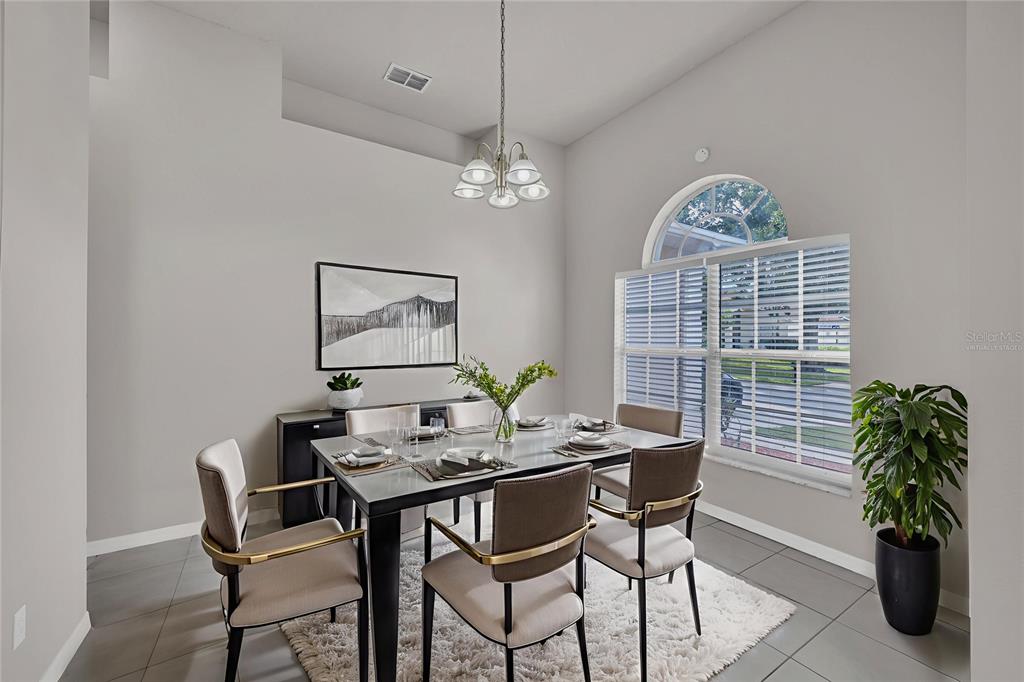 1047 Durango Loop Street Davenport, FL 33897 - Photo 4 of 35 a dining room with furniture potted plants and a chandelier