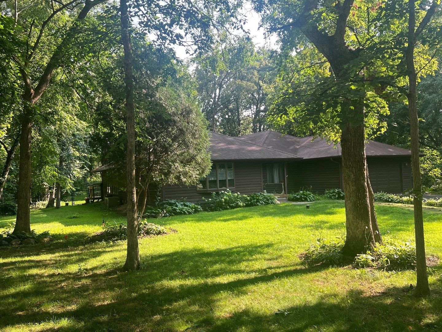 12970 Briody Way Genoa, IL 60135 - Photo 2 of 45 a view of a swimming pool with a table and a large tree