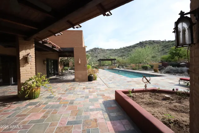 a view of a hallway with wooden floor and a bathroom