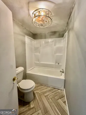 a bathroom with a toilet and a bathtub